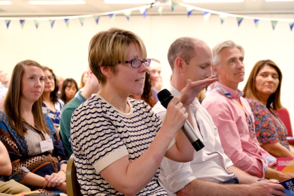 EWR colleagues sat at an event with one woman speaking into a microphone