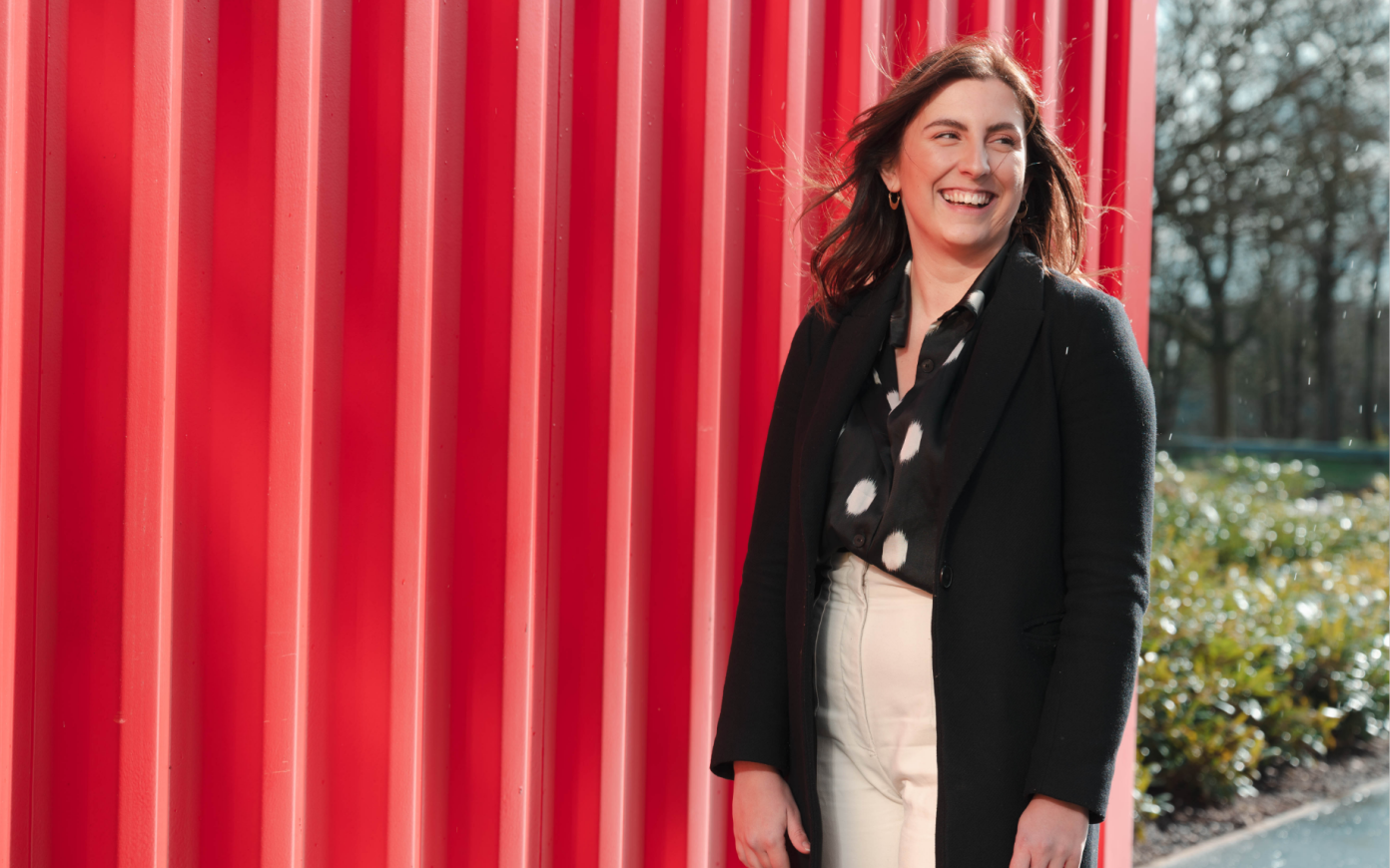 Ellen standing in front of red wall