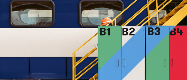 A set of marked lockers in front of a train