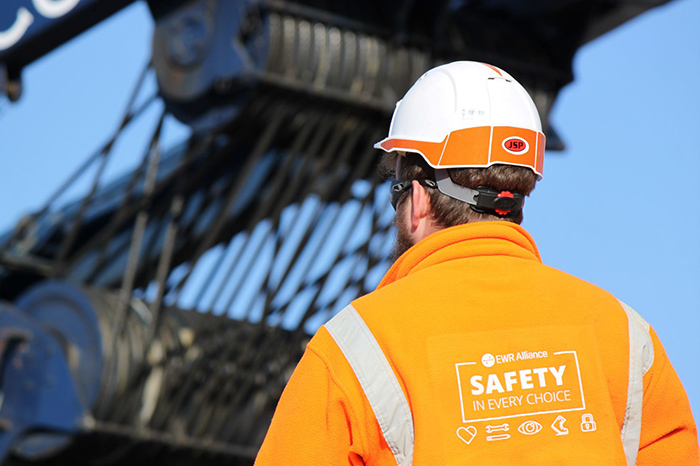 Image of construction worker from behind in hi vis and hardhat