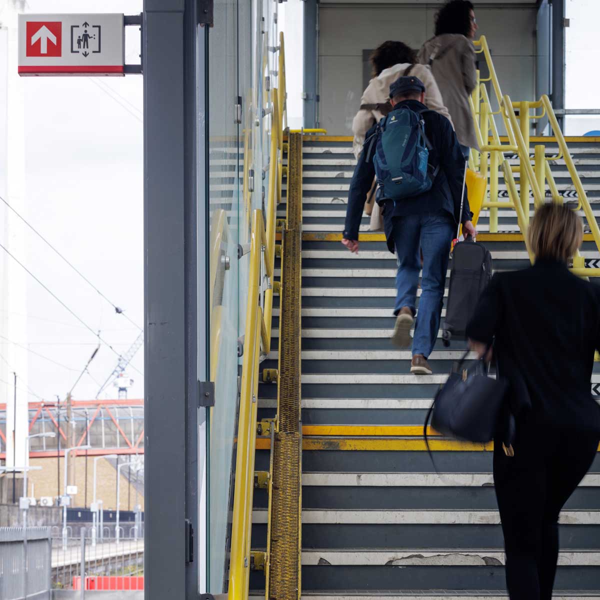 People walking up train station stairs