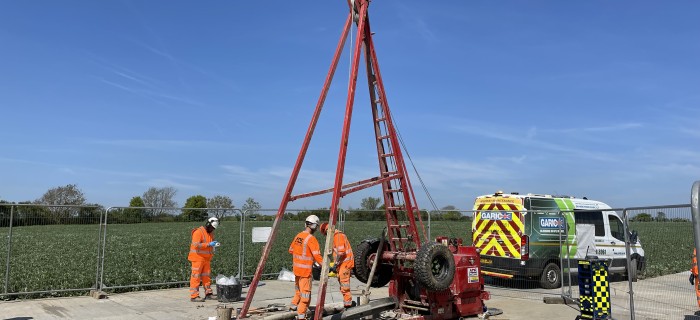 Image with two construction workers drilling into ground
