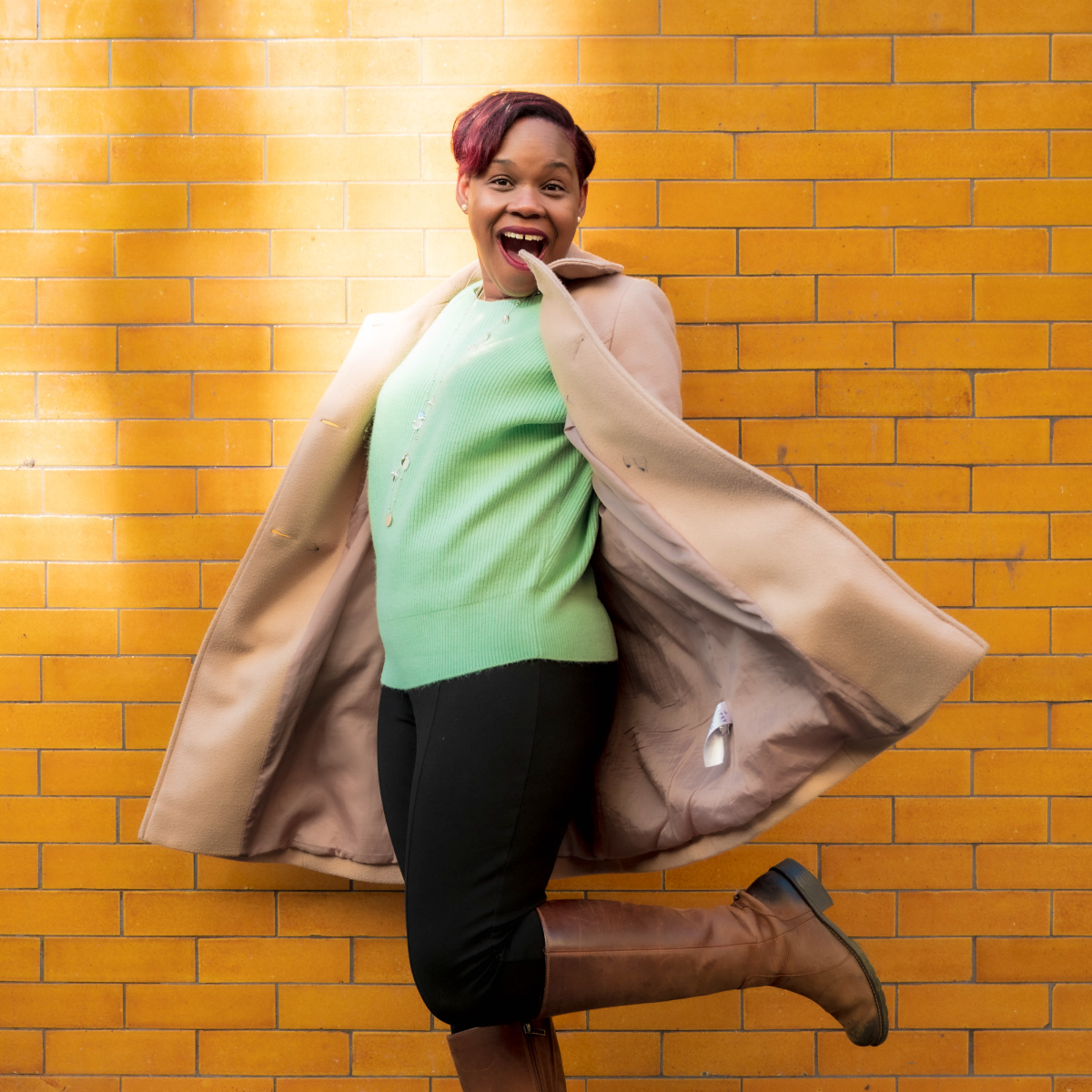 Kerene standing against yellow brick wall