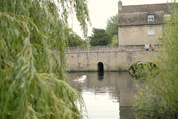people walking across bridge over river