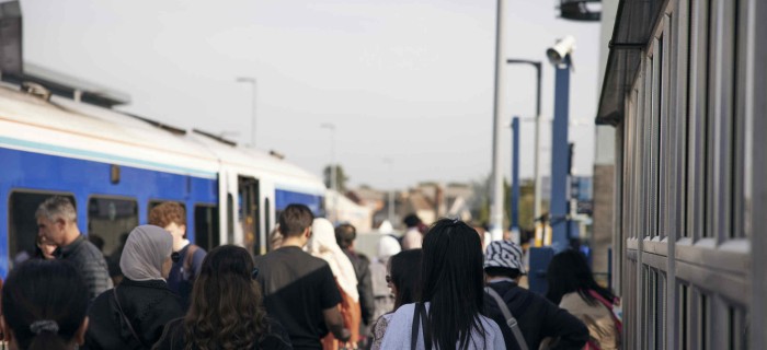 people walking on platform towards train