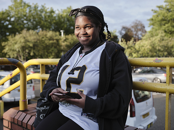 girl sitting on bench at train station
