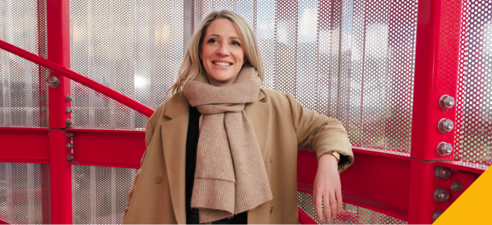 Hannah leaning against banister in stairwell